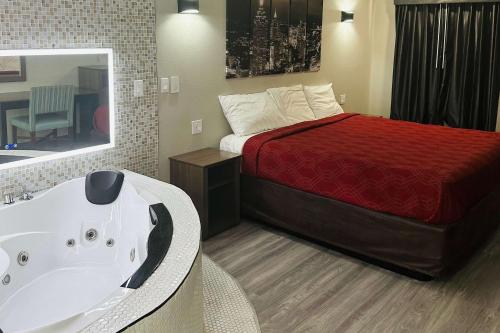 a bathroom with a bed and a bath tub next to a sink at Econo Lodge Union City - Atlanta South in Union City