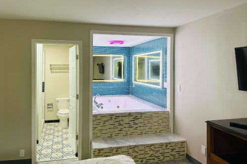 a bathroom with a tub with a window and a toilet at Econo Lodge Union City - Atlanta South in Union City
