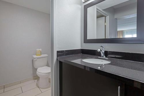 a bathroom with a sink and a toilet and a mirror at Clarion Hotel & Suites BWI Airport North in Baltimore