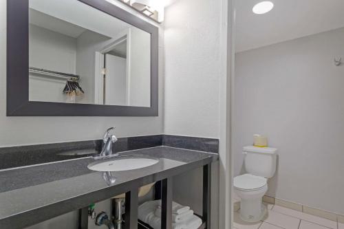 W łazience znajduje się umywalka, toaleta i lustro. w obiekcie Clarion Hotel & Suites BWI Airport North w mieście Baltimore