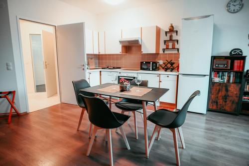 een keuken en eetkamer met een tafel en stoelen bij Vienna Shopping Center 14 Apartment in Wenen