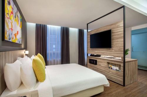 a bedroom with a large bed and a television at Days Hotel & Suites by Wyndham KL - Chan Sow Lin MRT or LRT in Kuala Lumpur
