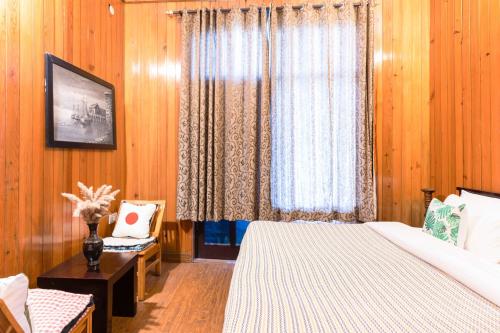 a bedroom with a bed and a window at Poetry by the Hills - House Of Hive, Ramgarh, Mukteshwar, Nainital in Rāmgarh