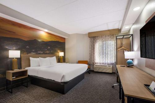 a hotel room with a bed and a desk at Clarion Pointe Sevierville-Pigeon Forge in Sevierville