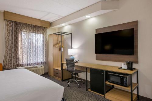a hotel room with a bed and a desk with a television at Clarion Pointe Sevierville-Pigeon Forge in Sevierville