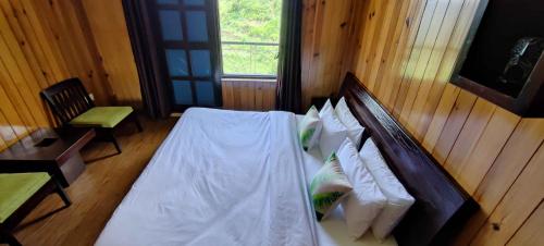 a bedroom with a bed with white sheets and pillows at Poetry by the Hills - House Of Hive, Ramgarh, Mukteshwar, Nainital in Rāmgarh