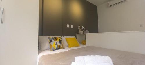 1 dormitorio con 1 cama con almohadas amarillas en Moderno e Reformado Studio em Copacabana, en Río de Janeiro