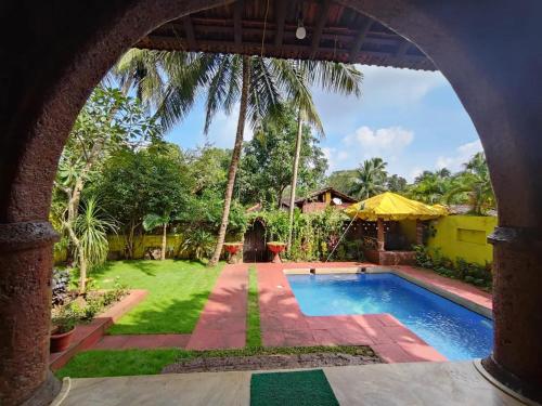 uma vista para um quintal com uma piscina em Siolim Villa Goa 3 bhk em Siolim