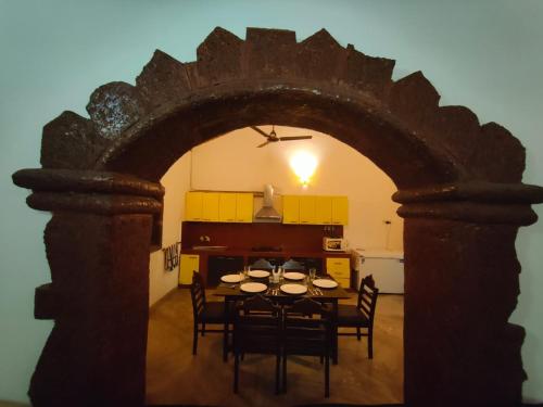 uma sala de jantar com uma mesa e cadeiras numa cozinha em Siolim Villa Goa 3 bhk em Siolim