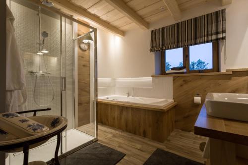 a bathroom with a shower and a sink and a tub at Aparthotel Bambi in Zakopane