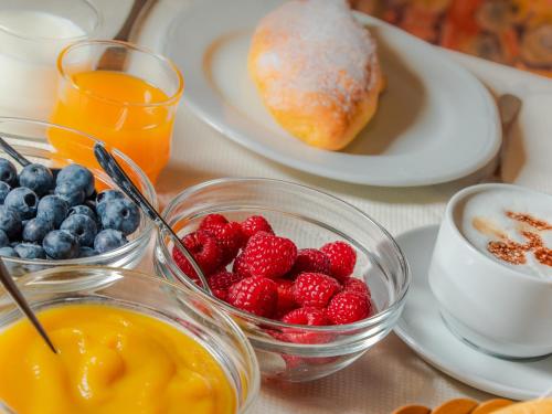 a table topped with bowls of fruit and a plate of food at Garnì La Grambla in Selva di Val Gardena
