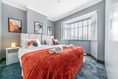 ein Schlafzimmer mit einem Bett mit Handtüchern darauf in der Unterkunft Stunning 3BR House w Garden & Parking in Richmond in Kew Gardens