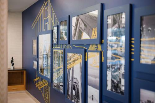a blue wall with pictures of buildings on it at Hyatt Place San Carlos in San Carlos