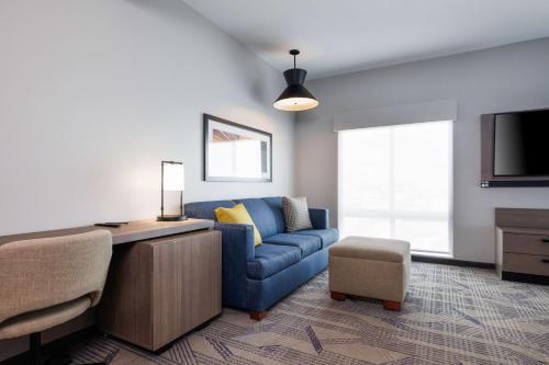 a living room with a blue couch and a tv at Hyatt Place San Carlos in San Carlos