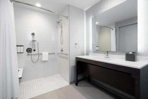 uma casa de banho branca com um lavatório e um chuveiro em Hyatt Place San Carlos em San Carlos