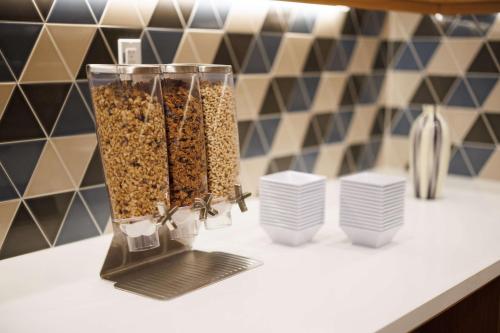 a counter with two vases filled with food on it at Hyatt Place San Carlos in San Carlos