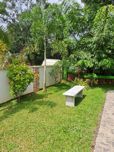 a bench sitting in the grass in a garden at Shamrock Inn in Cochin