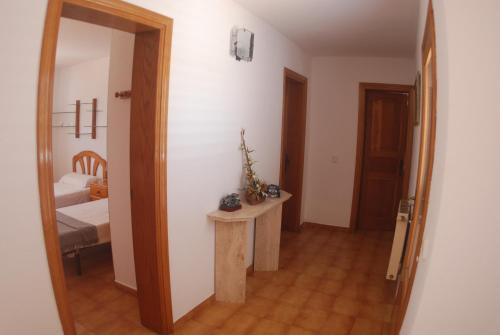um corredor com um quarto com uma cama e um espelho em Can Pinato em Cala Llonga