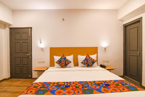 a bedroom with a large bed with colorful pillows at FabHotel Sayeeda International in Kolkata