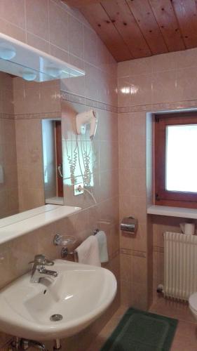a bathroom with a sink and a mirror at Garnì La Grambla in Selva di Val Gardena
