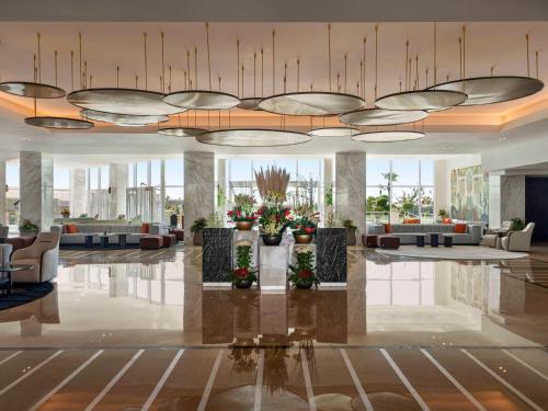 een lobby met banken en bloemen in een gebouw bij Rixos Golf Villas And Suites Sharm El Sheikh in Sharm El Sheikh