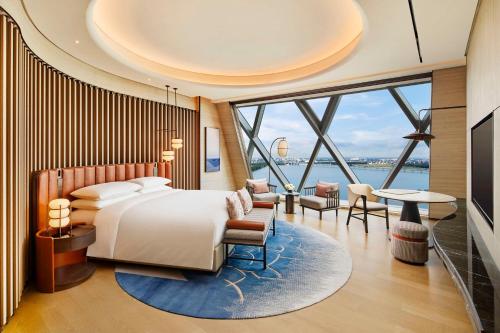 a bedroom with a bed and a large window at Hilton Huzhou Nanxun in Huzhou
