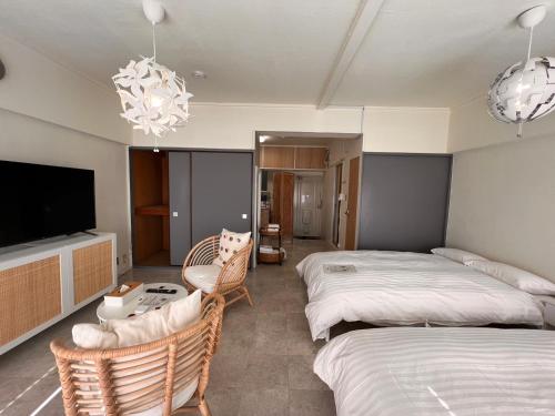 a bedroom with two beds and a flat screen tv at 白浜バケーションレンタル　SVR in Shirahama