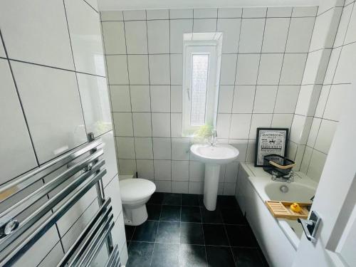 a white bathroom with a sink and a toilet at Mitchell Apartment by Klass Living Coatbridge in Coatbridge
