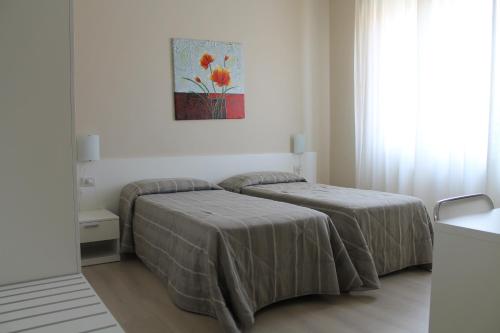 ein Schlafzimmer mit 2 Betten und einem Wandgemälde in der Unterkunft Hotel Cremona Viale in Cremona