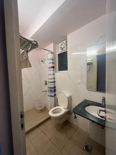 a bathroom with a white toilet and a sink at The Nest Lucknow in Lucknow