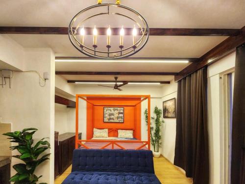 a living room with a blue couch and a bed at The Nest Lucknow in Lucknow