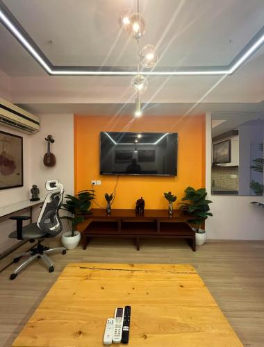 a living room with a flat screen tv on a wall at The Nest Lucknow in Lucknow
