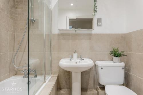 a bathroom with a toilet and a sink and a shower at StarHost Residences - Modern 2 bed apartment at Imperial Court, Newbury in Newbury