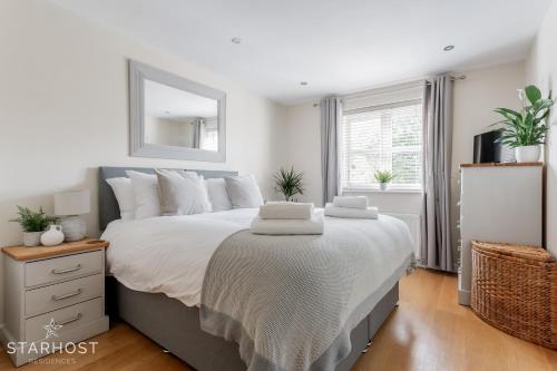 Modern 2 bed apartment at Imperial Court, Newbury في نيوبري: غرفة نوم بسرير كبير ومرآة عليها