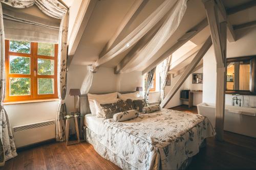 a bedroom with a bed and a window at Romantic Hotel Mlýn Karlstejn in Karlštejn