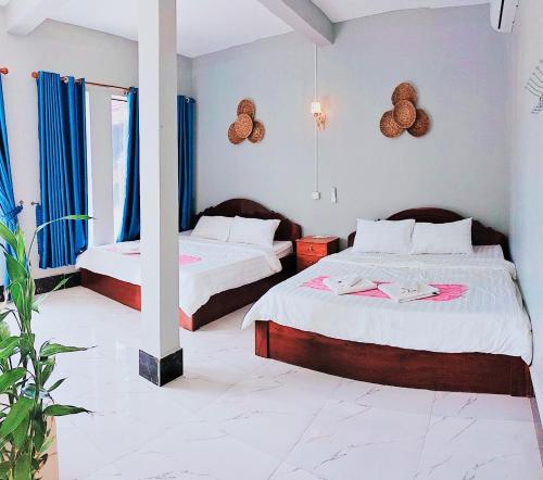 um quarto com 2 camas com cortinas azuis em Kampot Nature Villa Resort em Kampot