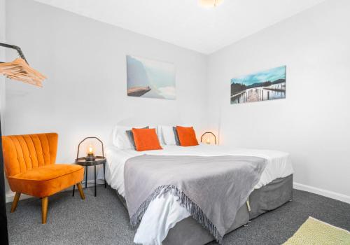 um quarto com uma cama e uma cadeira em McCulloch Apartment by Klass Living Uddingston em Uddingston