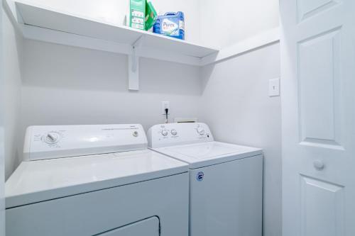 a white laundry room with a washer and dryer at Newly Renovated Downtown Apartment in the Historic District, Quiet Street! in Mobile