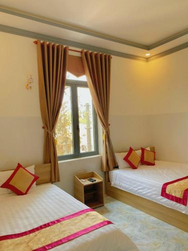 a bedroom with two beds and a window at Lak village in Lien Son