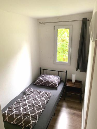 a bed in a small room with a window at Monteur-Haus Linde in Biesenthal