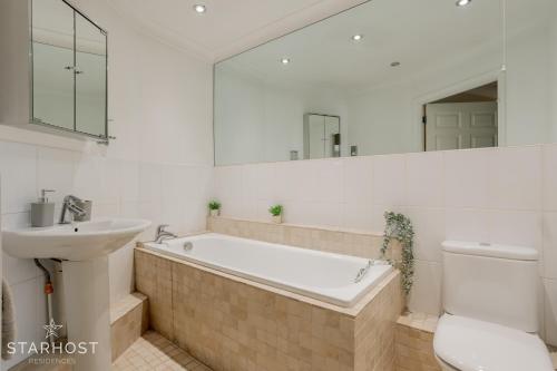 y baño con bañera, lavabo y aseo. en Smart 2 Bedroom Apartment in Newbury en Newbury