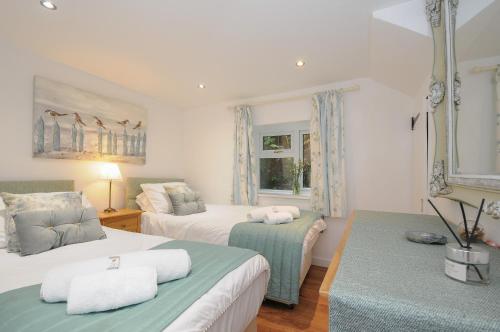 a bedroom with two beds and a window at Moon's Cottage in Fowey