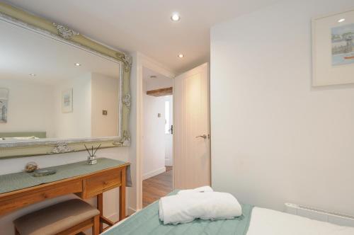 ein Badezimmer mit Waschbecken und Spiegel in der Unterkunft Moon's Cottage in Fowey