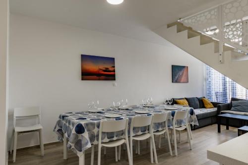 Villa Miri III في بريفلاكا: غرفة طعام بيضاء مع طاولة وكراسي