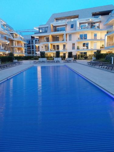 a large swimming pool in front of a building at Sailors' Park Villa Zephir in Nieuwpoort