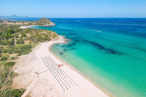 - une vue aérienne sur une plage avec des parasols et l'océan dans l'établissement Spiagge San Pietro, a charming & relaxing resort, à Castiadas