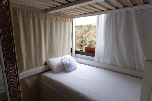 Cama en habitación con ventana en Casanaga, en Almáciga