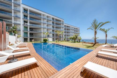una imagen de un hotel con piscina y sillas en Royal Sea View III, en Funchal