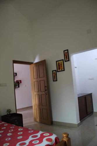 a room with a door and pictures on the wall at Munnar Village Homes in Munnar