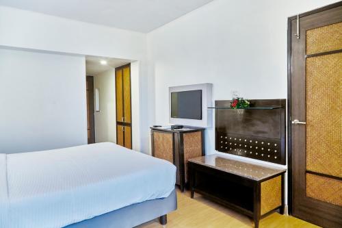 a hotel room with a bed and a television at Hotel Orion Centrally near North Goa & Panjim in Porvorim